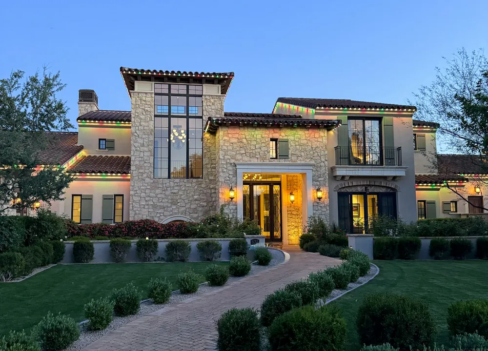 Warm Mediterranean-style luxury home lit at dusk in Westboro